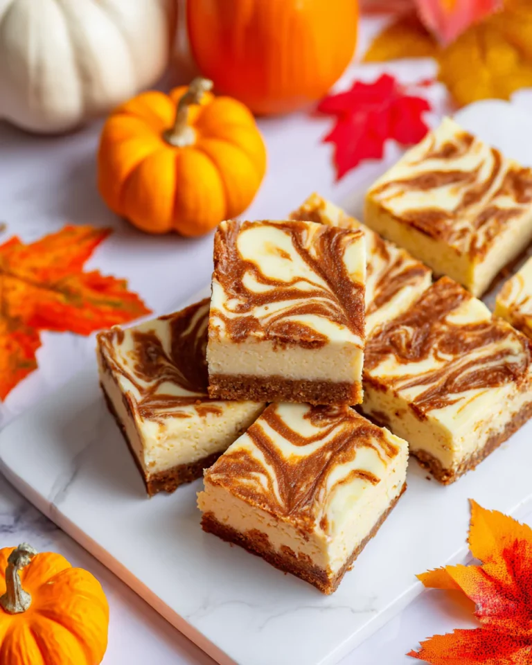 Sliced swirled pumpkin cheesecake bars on a platter